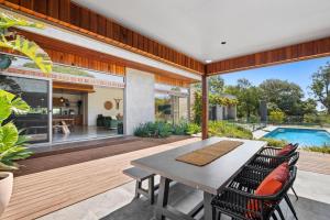 a patio with a table and chairs and a swimming pool at Oasis on Aquarius in Torquay