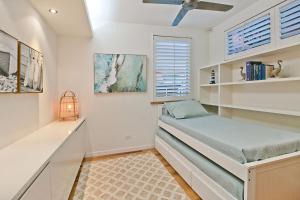 Beachfront Bliss في غولد كوست: غرفة نوم صغيرة بها سرير ونافذة