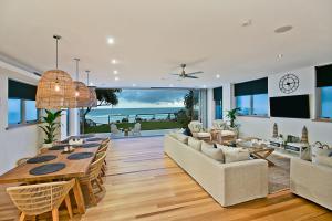 Beachfront Bliss في غولد كوست: غرفة طعام وغرفة معيشة مع طاولة وكراسي