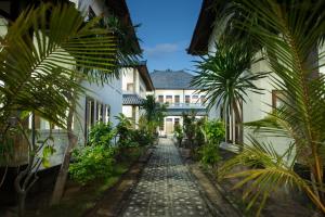 a cobblestone alley between two buildings with palm trees at Linda Beach Hotel in Nusa Lembongan