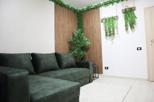 a living room with a couch and some plants at BROWNIX Apartment - Brown Residence in Popeşti-Leordeni