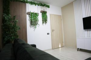 a living room with a couch and a door with plants at BROWNIX Apartment - Brown Residence in Popeşti-Leordeni