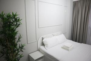 a white couch in a white room with a plant at BROWNIX Apartment - Brown Residence in Popeşti-Leordeni +8 photos