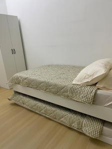 a bed in a bedroom with a white wall at Comfy house in Melaka City Centre in Malacca