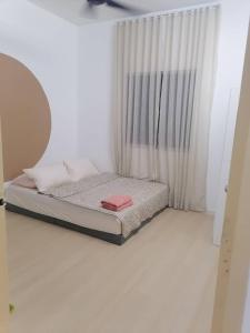 a small bed in a room with a window at Comfy house in Melaka City Centre in Malacca