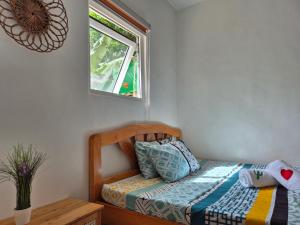 a small bedroom with a bed and a window at Amazing Ocean View Treehouse & Pool in Puerto Princesa City +19 photos