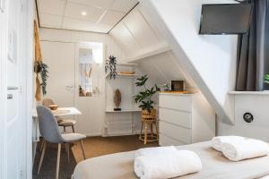 a room with two beds and a table and a desk at Stylish Suite Steps To Shore in Zoutelande