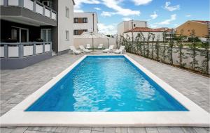 a swimming pool in the backyard of a house at 1 Bedroom Lovely Apartment In Vrsi in Vrsi