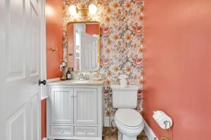 une salle de bain avec des toilettes blanches et un miroir dans l'établissement Downtown Lancaster Retreat - Amish County, à Lancaster 26 autres photos