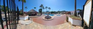 a resort with a pool and palm trees and a fence at Villa Serena Erizos 2 in San Carlos