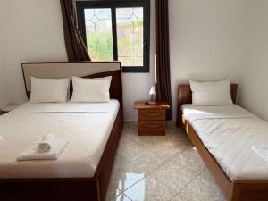 a room with two beds and a window at Vila Bilali in Ksamil