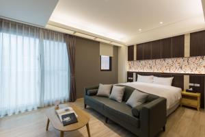 una camera da letto con un letto e un divano di 視界民宿-證號1714,1763- a Città di Hualien