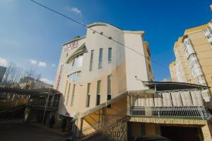 a white building with a sign on the side of it at Villa Arus in Chişinău