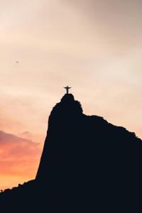 a cross on top of a mountain at sunset at Cozy House in Rio de Janeiro