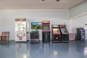 a group of arcade machines lined up in a room at Cozy Home with Pool Access in Surf City in Holly Ridge
