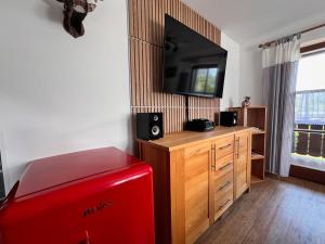 a room with a red refrigerator and a flat screen tv at Ferienwohnung Sonnenglück in Schönau am Königssee