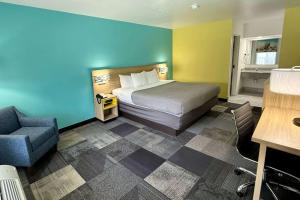 ニスビルにあるDays Inn by Wyndham Eglin AFBのベッドと椅子付きのホテルルーム