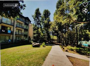 a walkway in front of a building with trees and grass at Departamento en Pucón in Pucón