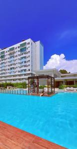 ドゥマゲテにあるNorman Condominium Unit Rental Sea Viewの大きな建物の前の大きなスイミングプール