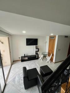 a living room with a couch and a flat screen tv at Maravillosa Vista al Mar en El Peñon del Rodadero in Gaira