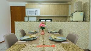 a dining table with plates and flowers in a kitchen at Refugio com Lazer Completo em Gravata in Gravatá