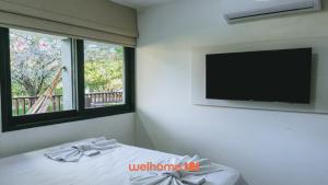 a bedroom with a flat screen tv and a bed at Refugio com Lazer Completo em Gravata in Gravatá