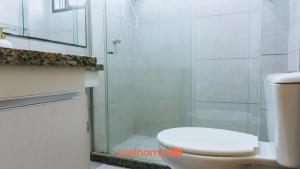 a bathroom with a toilet and a glass shower at Refugio com Lazer Completo em Gravata in Gravatá