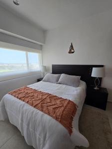 a bedroom with a large bed with a large window at Descanso en ACAPULCO DIAMANTE in Acapulco