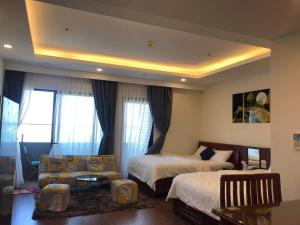 a hotel room with two beds and a couch at FLC Sea tower Quy Nhon in Quy Nhon