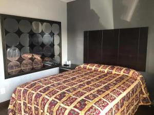 a bedroom with a bed with a large head board at El Grande Motel in South Gate