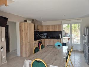 a dining room with a table and chairs and a kitchen at Maison de vacances à Fort Mahon Plage, Baie d'Authie - FR-1-482-154 in Fort-Mahon-Plage +3 photos