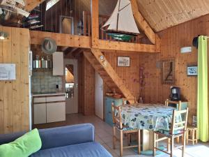 un salon avec une table et une cuisine dans l'établissement Chalet authentique près de la plage pour 6 personnes - FR-1-788-65, à Merville-Franceville-Plage 9 autres photos