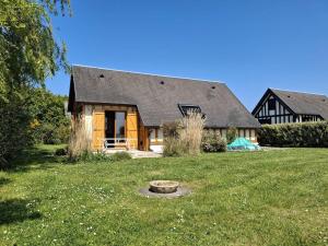 une maison avec une grande cour et une maison dans l'établissement Chalet authentique près de la plage pour 6 personnes - FR-1-788-65, à Merville-Franceville-Plage
