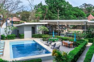 eine Außenterrasse mit Swimmingpool und ein Haus in der Unterkunft WET hotel - Adults Only in Tamarindo