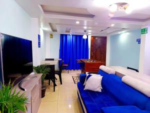 a living room with a blue couch and a piano at Hostal Valle Andino in El Tambo