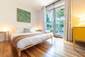 una camera da letto con un letto e una grande finestra di 2BR Elsternwick Escape with Courtyard a Melbourne