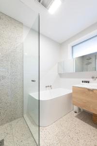 un bagno bianco con vasca e lavandino di 2BR Elsternwick Escape with Courtyard a Melbourne