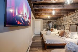 una camera con tre letti e una TV a parete di Downtown Retreat with Modern Comfort a Montréal