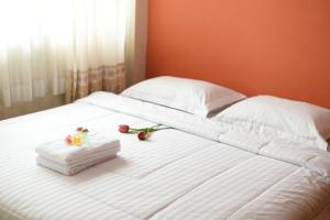ein weißes Bett mit Handtüchern und Blumen darauf in der Unterkunft Roemah 28 Syariah in Medan + 97 Fotos