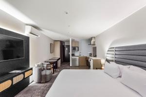 a hotel room with a large bed and a kitchen at Marsden Suites Albany in Albany