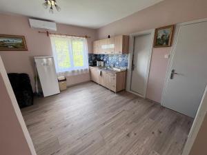 an empty room with a kitchen with a refrigerator at Nap körút Apartman in Tiszakécske