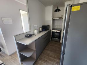 a small kitchen with a counter and a refrigerator at Departamento Centro Puerto Montt in Puerto Montt