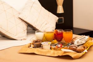 a tray of food and drinks on a bed at Vercelli Palace Hotel in Vercelli +52 photos