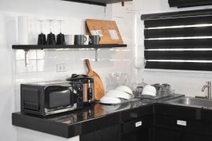 a kitchen counter with a microwave and a sink at Balai Modern Home in Baguio