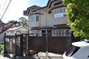 a house with a black gate and a fence at Balai Modern Home in Baguio