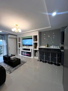 a large living room with a tv and a table at 2 Bedrooms 2 Bathrooms Luxury Gated Condo with Beach and Breathtaking Views of Kingston Harbour and 2 swimming Pools in Portmore