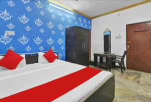 a bedroom with a bed with red pillows and a desk at PREMIUM THE BEST HOTEL Near Railway Station - Wifi and Fully Air Conditioning Room - Prime Location - Room Service and Excellent Customer Service Awarded in Bādshāhnagar