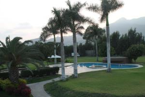 Casa Blanca HaciendaCasa de Campo 15 people with a pool的有游泳池和棕榈树的度假村