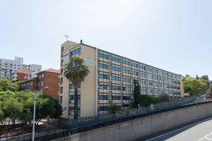 a tall building with a palm tree in front of it at Mountway Holiday Apartments in Perth