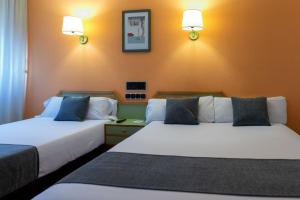 A bed or beds in a room at Hotel Alda Guijuelo